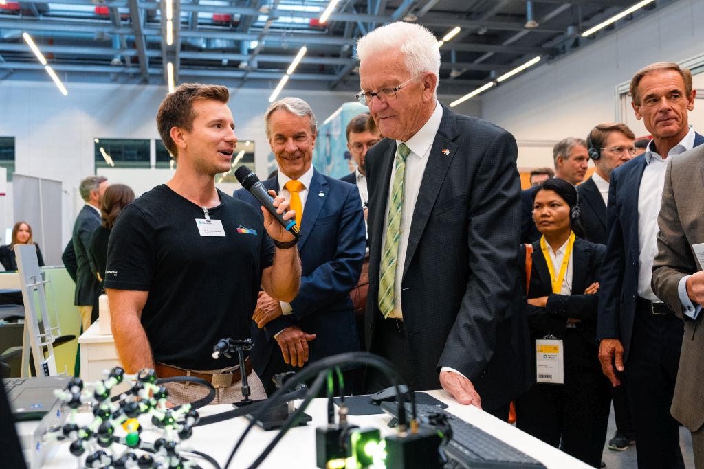 Christian Tutschku gives Winfried Kretschmann a tour of the booth.