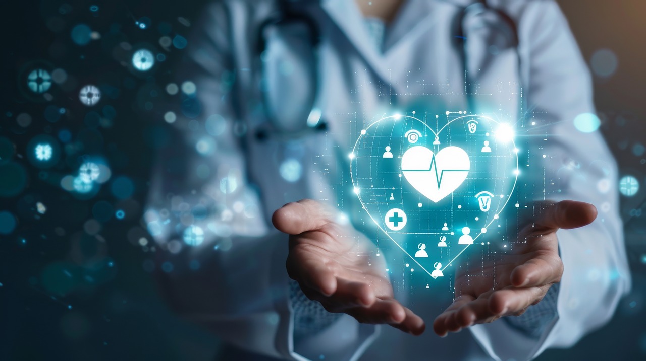 Medizinisches Fachpersonal hält holografisches Herz mit verschiedenen medizinisch anmutenden Icons in beiden Händen.